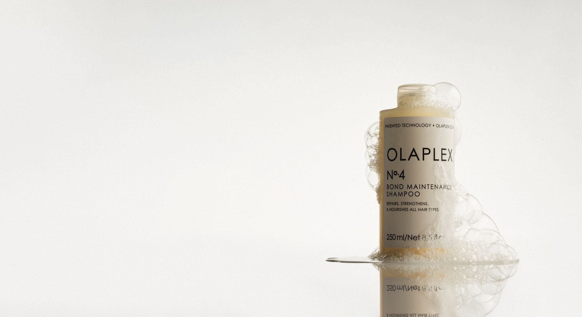No.4 Bond Maintenance Shampoo with shampoo suds on the bottle