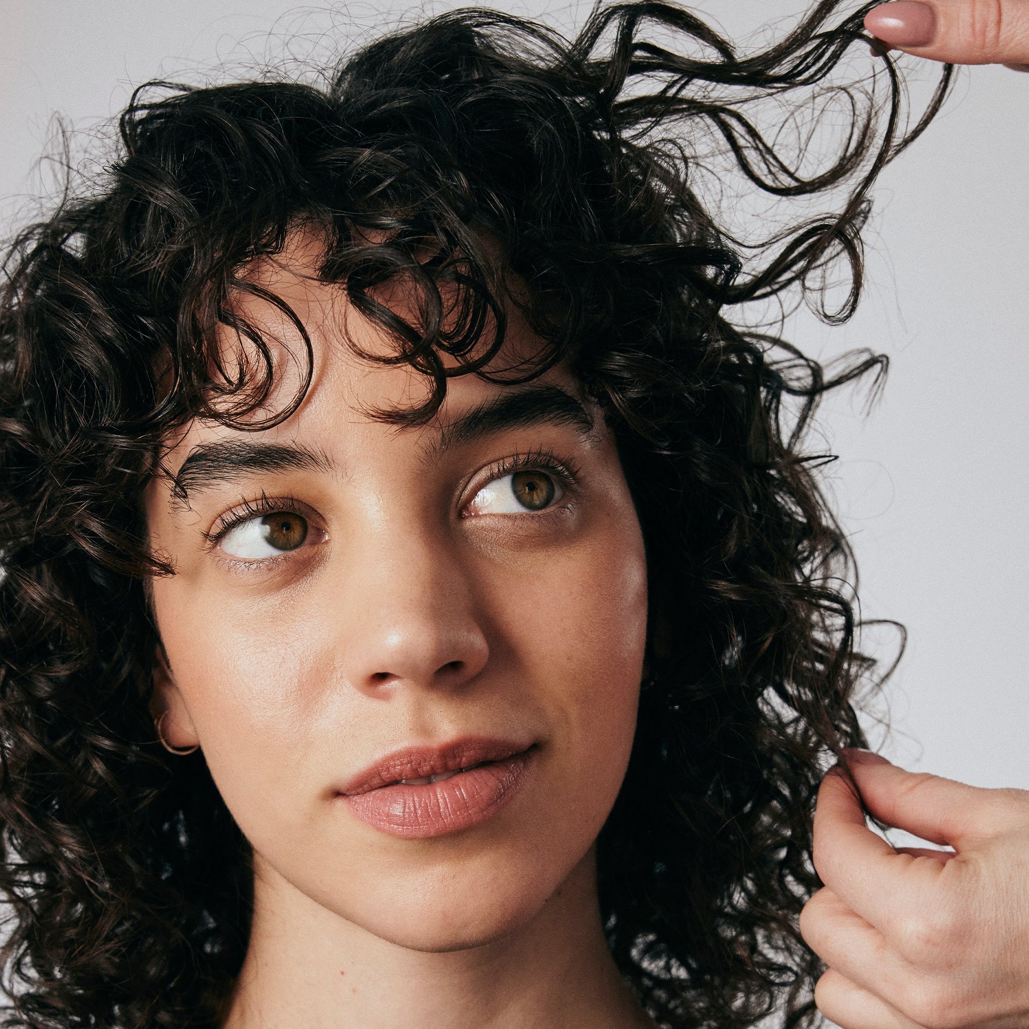 A woman getting her curly hair styled
