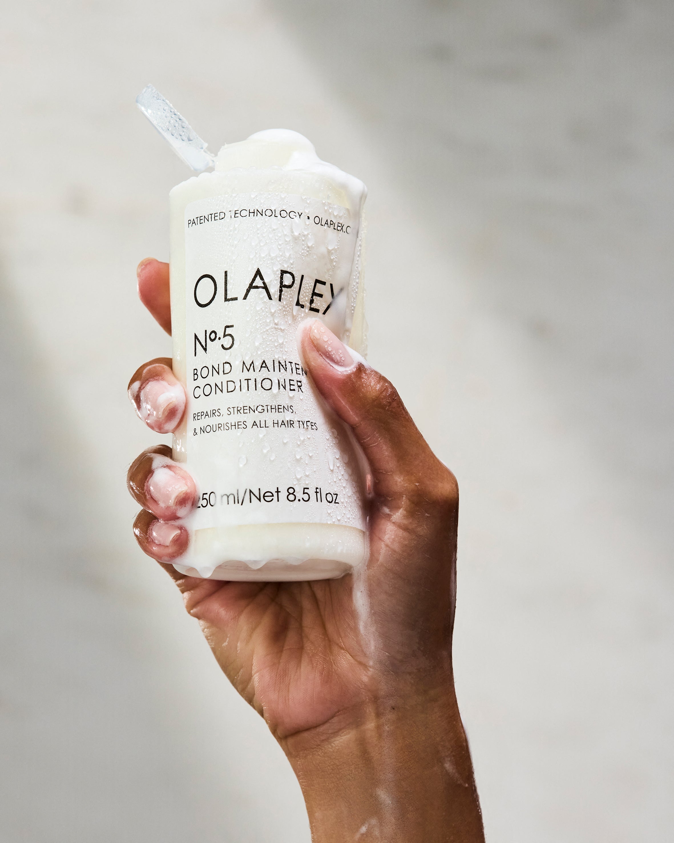 Hand holding No.5 in the shower