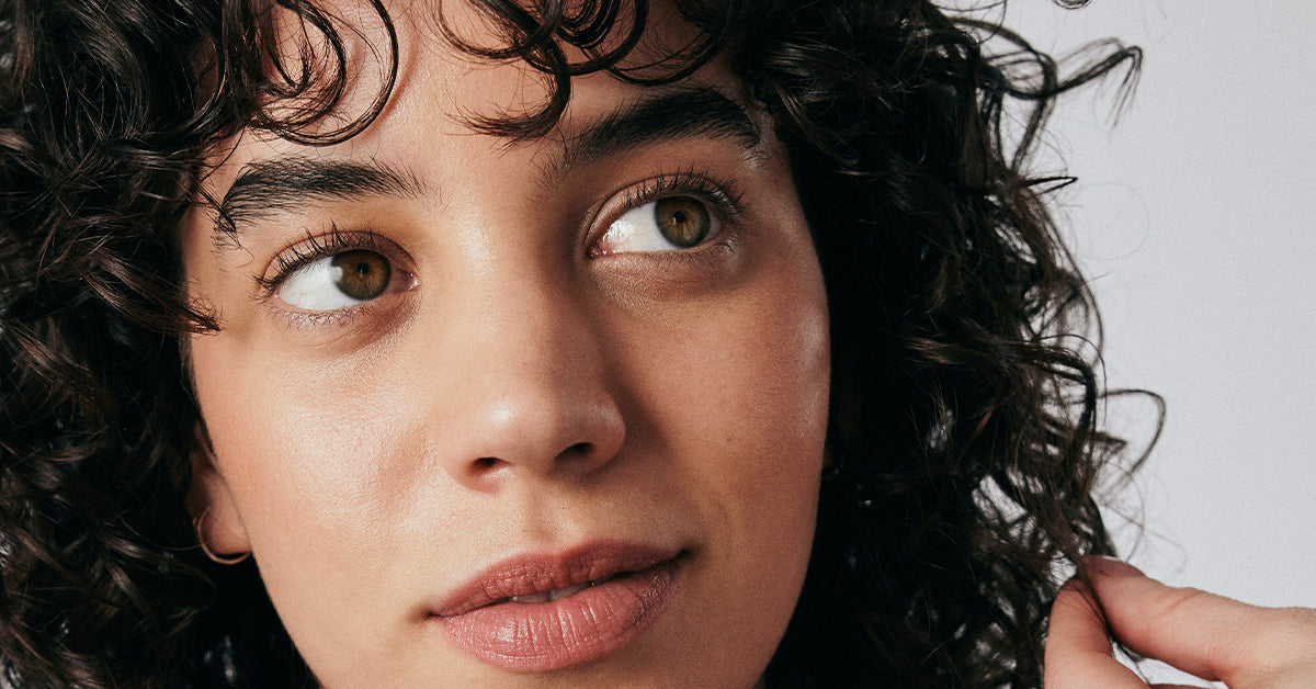Woman with brown curly hair looking to the side