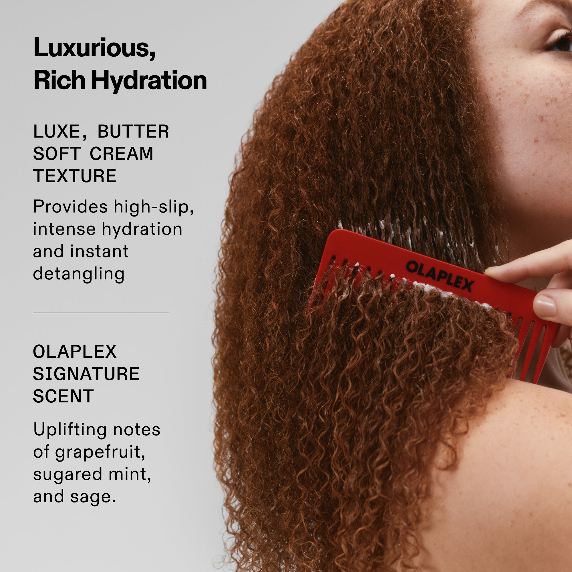 Immagine intitolata "Idratazione ricca e lussuosa" che ritrae una modella mentre utilizza un pettine OLAPLEX rosso tra i capelli ricci. Il testo descrive una texture in crema lussuosa e morbida come il burro, per un'azione districante immediata e ad alto setosità. Mette in risalto il caratteristico profumo di OLAPLEX con tonificanti note di pompelmo, menta zuccherata e salvia.