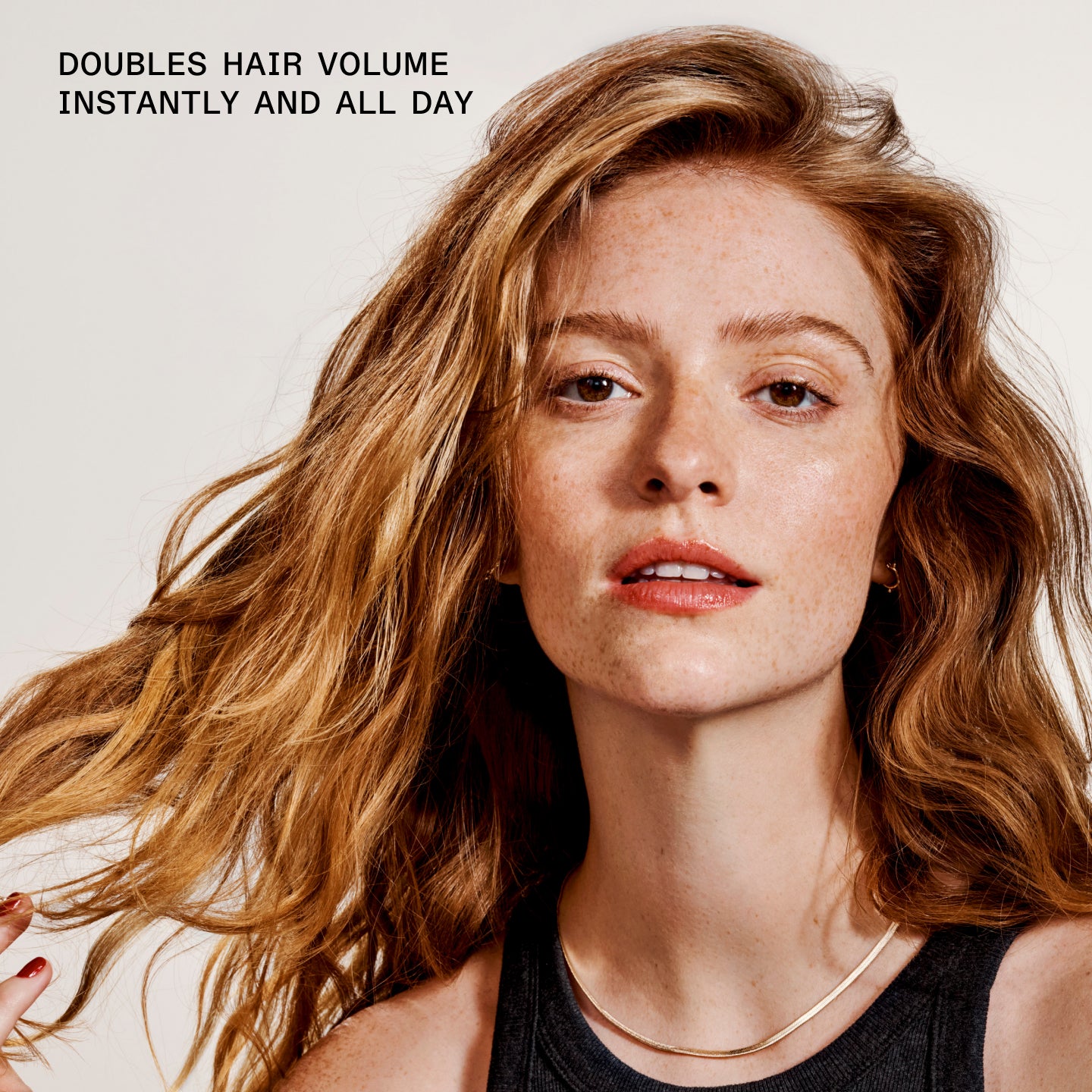 Large text overlay: "DOUBLES HAIR VOLUME INSTANTLY AND ALL DAY"

Suggestion/Metadata (on the right): "Woman with voluminous hair against a plain background"