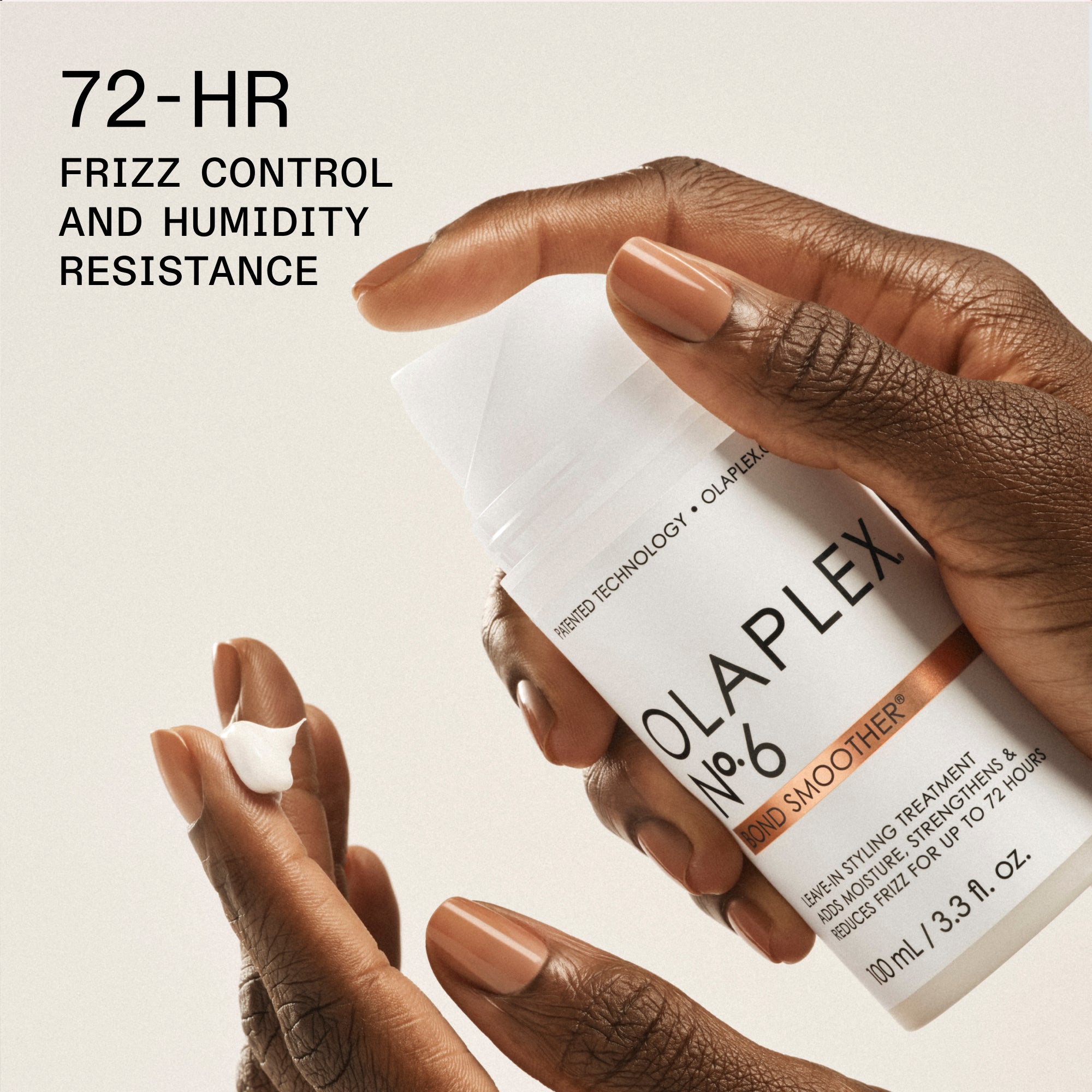 Una foto ravvicinata della mano di una persona con le unghie dipinte di marrone con in mano un flacone bianco di "OLAPLEX N°.6 BOND SMOOTHER® LEAVE-IN STYLING TREATMENT (100 ml/3,3 fl. oz.)". Nell'angolo in basso a sinistra, una piccola quantità di crema bianca riposa sulla punta delle dita della persona. Il testo nero in grassetto nell'angolo in alto a sinistra recita "72 ORE DI CONTROLLO DELL'EFFETTO CRESPO E RESISTENZA ALL'UMIDITÀ".